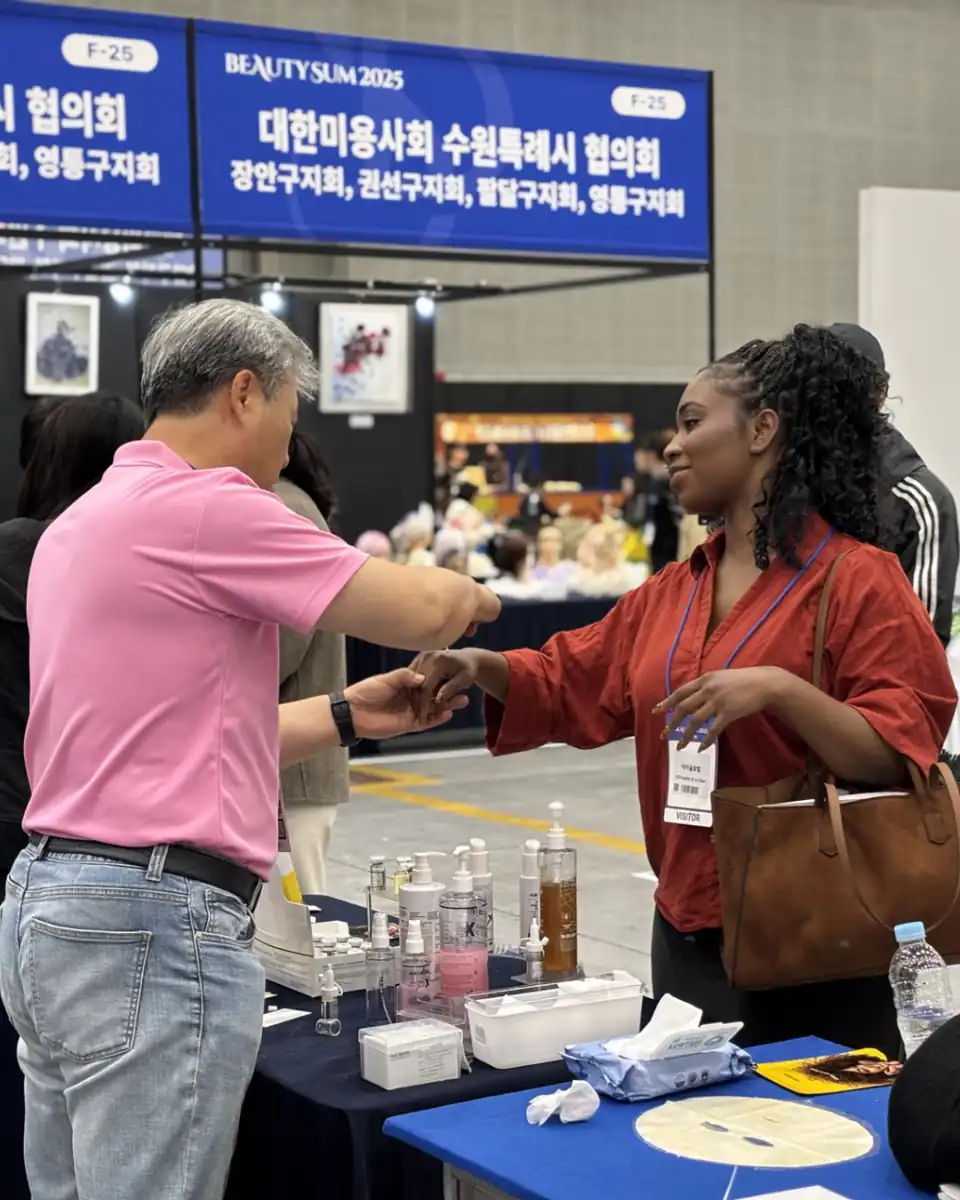 부스에서 손등에 제품을 발라 보는 관람객