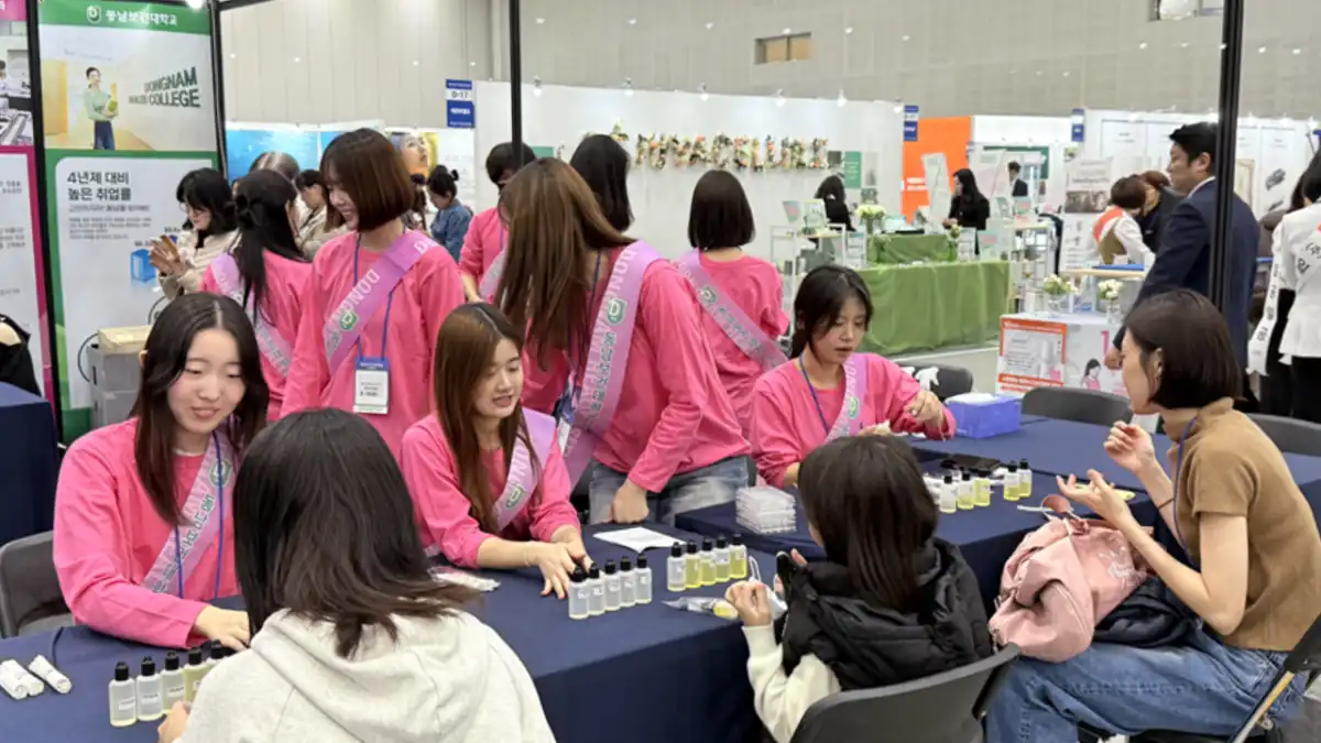 분홍 조끼를 입은 스태프가 관람객을 맞는 체험 부스